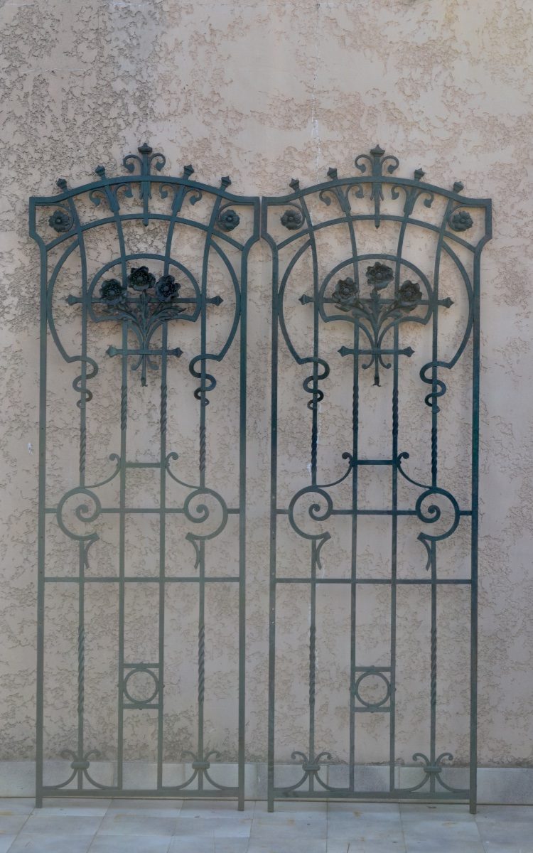 Wrought-iron gates leaning against a wall
